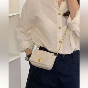 Quilted crossbody bag with gold chain.